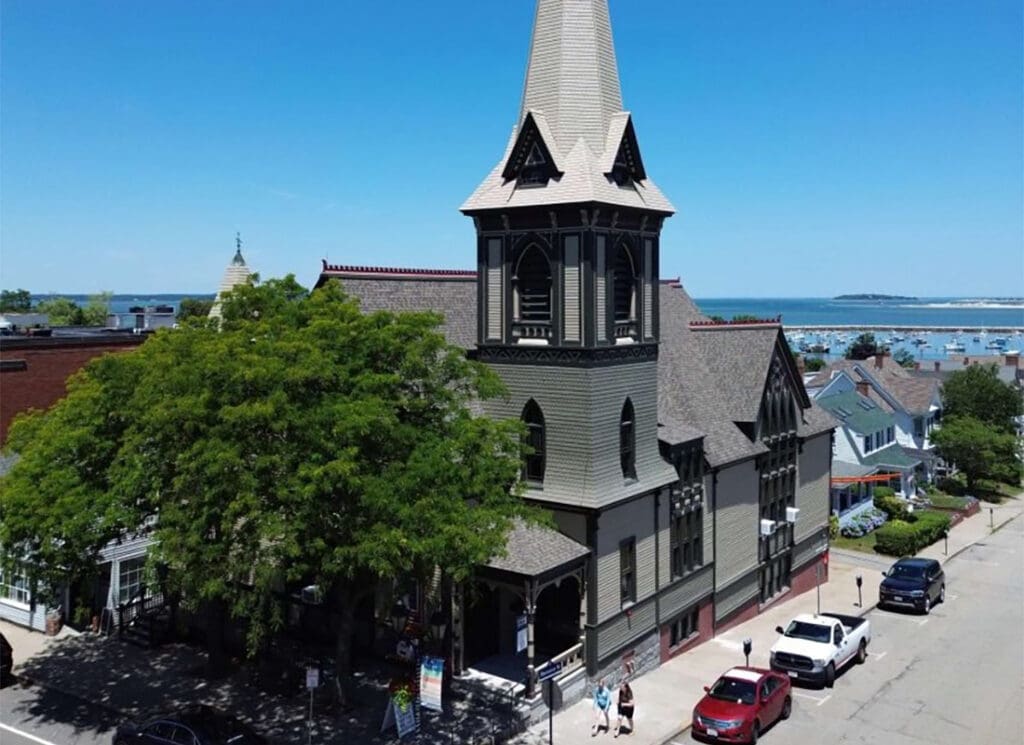 About Our Agency - Aerial View of a Church on a Main Street by the Coast in New England on a Sunny Day