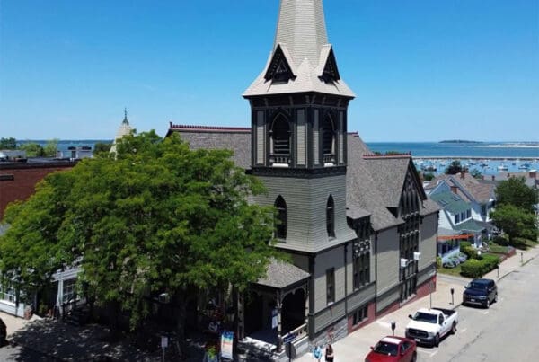 About Our Agency - Aerial View of a Church on a Main Street by the Coast in New England on a Sunny Day