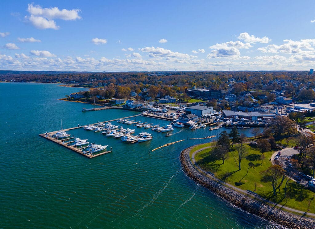 Plymouth, MA - Aerial View of Plymouth Massachusetts Land By the Coast with Boats on the Water
